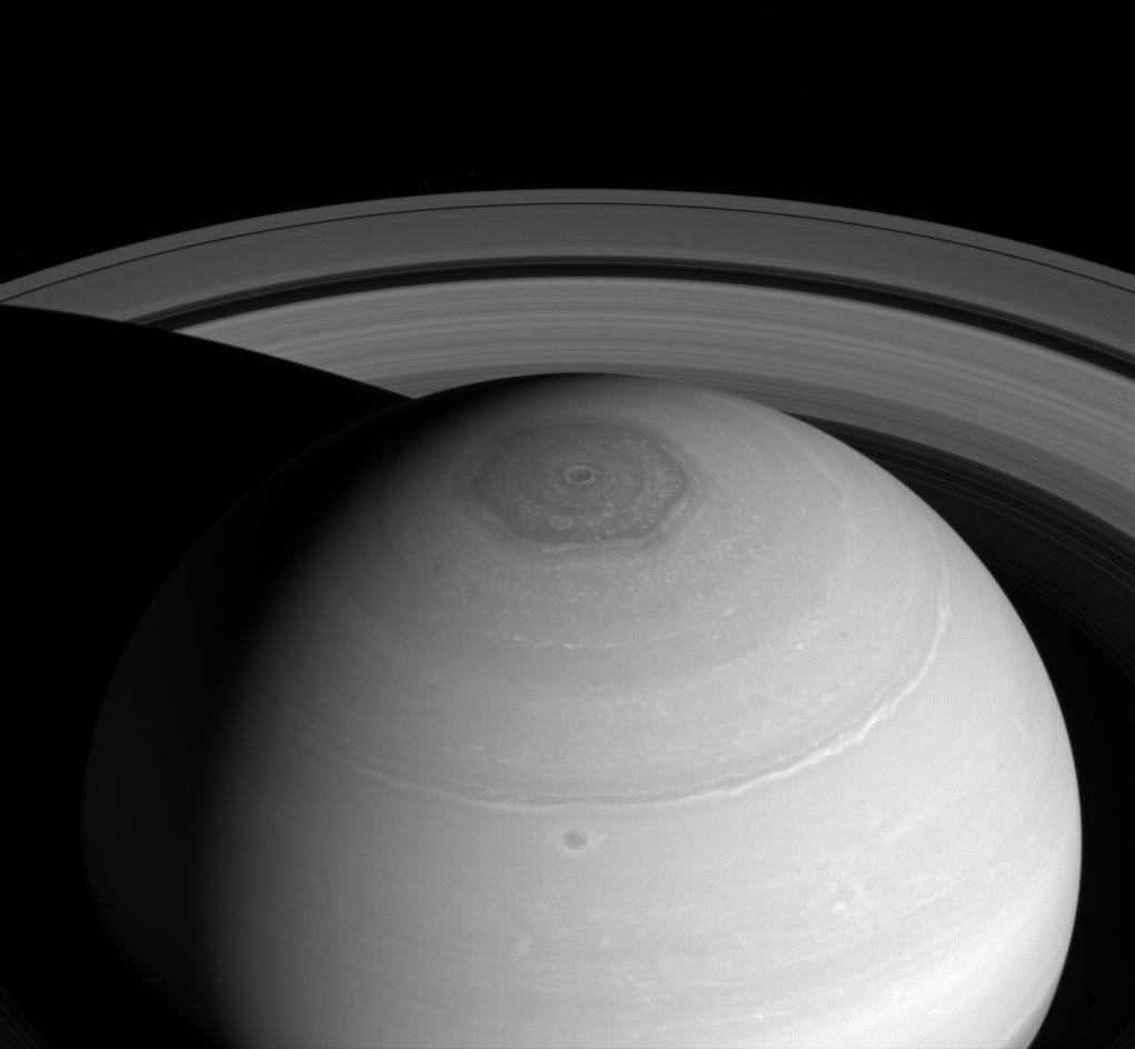 Cassini view of Saturn's six-sided north polar hexagon with the rings arcing above, taken in near-infrared light